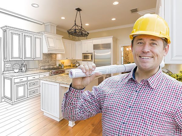 contractor holding a blueprint in a kitchen